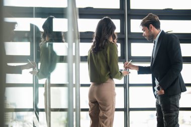 İş adamları iş yerinde eğleniyor ve sohbet ediyorlar. Erkek ve bayan meslektaşlar ortak çalışma alanında tanışmaktan hoşlanırlar. İş arkadaşlarım ofiste projeyi tartışıyorlar..