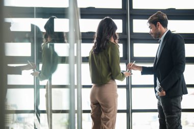 İş adamları iş yerinde eğleniyor ve sohbet ediyorlar. Erkek ve bayan meslektaşlar ortak çalışma alanında tanışmaktan hoşlanırlar. İş arkadaşlarım ofiste projeyi tartışıyorlar..