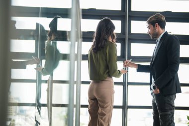 İş adamları iş yerinde eğleniyor ve sohbet ediyorlar. Erkek ve bayan meslektaşlar ortak çalışma alanında tanışmaktan hoşlanırlar. İş arkadaşlarım ofiste projeyi tartışıyorlar..