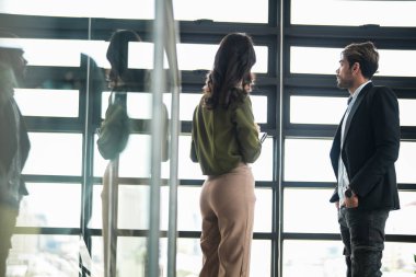 İş adamları iş yerinde eğleniyor ve sohbet ediyorlar. Erkek ve bayan meslektaşlar ortak çalışma alanında tanışmaktan hoşlanırlar. İş arkadaşlarım ofiste projeyi tartışıyorlar..