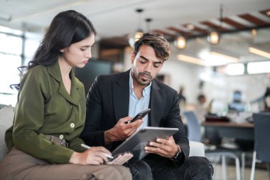 İş yerindeki işadamları konuşuyor. Erkek ve bayan meslektaşlar rahatlamayı ve koltukta oturmayı severler. İş arkadaşları ofiste projeyi tartışıyor. Görevdeki gençlerden oluşan bir takım.