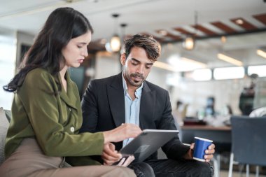 İş yerindeki işadamları konuşuyor. Erkek ve bayan meslektaşlar rahatlamayı ve koltukta oturmayı severler. İş arkadaşları ofiste projeyi tartışıyor. Görevdeki gençlerden oluşan bir takım.