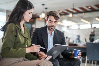 İş yerindeki işadamları konuşuyor. Erkek ve bayan meslektaşlar rahatlamayı ve koltukta oturmayı severler. İş arkadaşları ofiste projeyi tartışıyor. Görevdeki gençlerden oluşan bir takım.