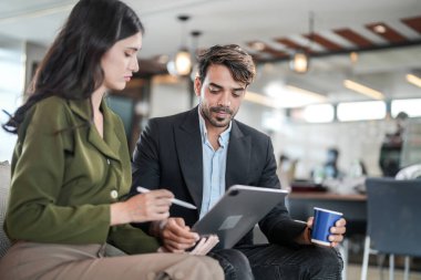İş yerindeki işadamları konuşuyor. Erkek ve bayan meslektaşlar rahatlamayı ve koltukta oturmayı severler. İş arkadaşları ofiste projeyi tartışıyor. Görevdeki gençlerden oluşan bir takım.