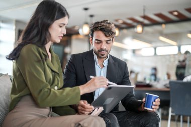 İş yerindeki işadamları konuşuyor. Erkek ve bayan meslektaşlar rahatlamayı ve koltukta oturmayı severler. İş arkadaşları ofiste projeyi tartışıyor. Görevdeki gençlerden oluşan bir takım.