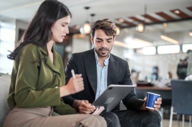 İş yerindeki işadamları konuşuyor. Erkek ve bayan meslektaşlar rahatlamayı ve koltukta oturmayı severler. İş arkadaşları ofiste projeyi tartışıyor. Görevdeki gençlerden oluşan bir takım.