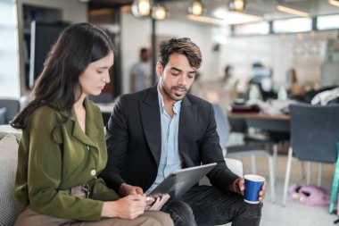 İş yerindeki işadamları konuşuyor. Erkek ve bayan meslektaşlar rahatlamayı ve koltukta oturmayı severler. İş arkadaşları ofiste projeyi tartışıyor. Görevdeki gençlerden oluşan bir takım.
