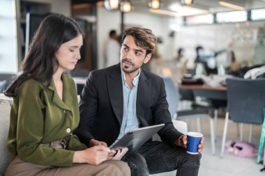 İş yerindeki işadamları konuşuyor. Erkek ve bayan meslektaşlar rahatlamayı ve koltukta oturmayı severler. İş arkadaşları ofiste projeyi tartışıyor. Görevdeki gençlerden oluşan bir takım.