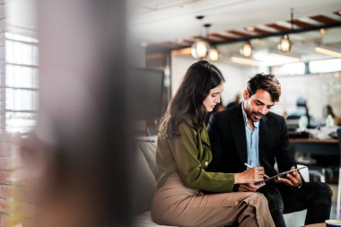 İş yerindeki işadamları konuşuyor. Erkek ve bayan meslektaşlar rahatlamayı ve koltukta oturmayı severler. İş arkadaşları ofiste projeyi tartışıyor. Görevdeki gençlerden oluşan bir takım.