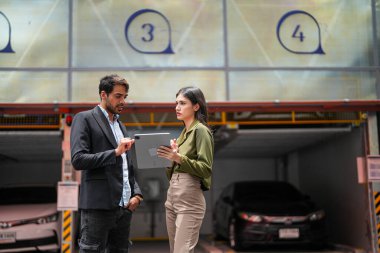 İş adamına araba satan profesyonel bir satış elemanı. Araba satışı. Garaj Otoparkı Mağazası 'ndaki İşadamı Alıcı' ya öneriler veriyor. Araba satıcısı satış danışmanı..