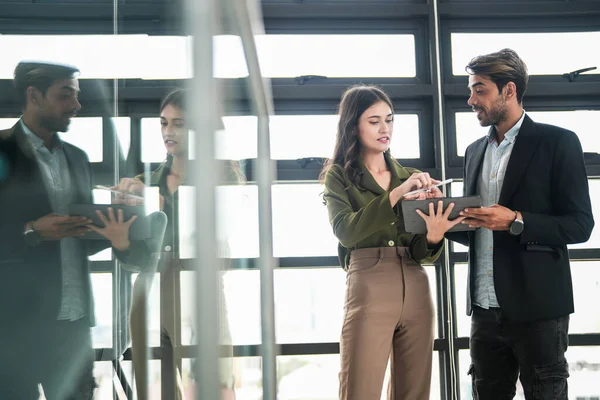 İş adamları iş yerinde eğleniyor ve sohbet ediyorlar. Erkek ve bayan meslektaşlar ortak çalışma alanında tanışmaktan hoşlanırlar. İş arkadaşlarım ofiste projeyi tartışıyorlar..