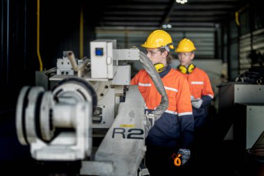 Erkek mühendis bir fabrikadaki otomatik robotik kol makinesini tamir ediyor. İşçi otomatik robot el makinesini kontrol ediyor ve onarıyor. Teknisyen, tamir makinesini kontrol et..