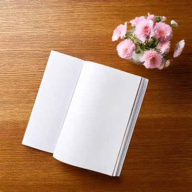 Boş beyaz bir kitap ve tahta bir arka planda çiçekler..