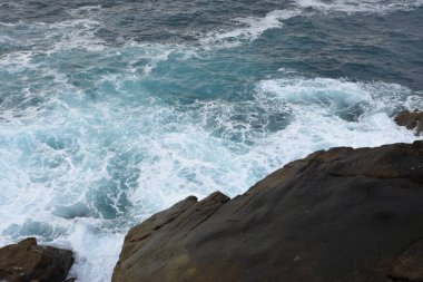 Deniz kıyısındaki taşlara vuran dalgaların görüntüsü