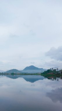 Yağmur mevsiminde göl ve dağ manzarası