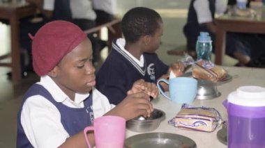 27 Ağustos 2023, Abuja Nijerya: Afrikalı Nijerya öğrencileri konferans odasında öğreniyor, el kaldırıyor, ders notları yazıyor ve sınıfta dinliyorlar. Öğretmenler öğrencilere öğretiyor