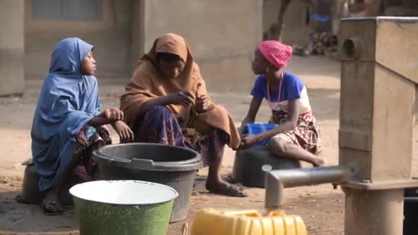 ジャン 2024 グワラダ ナイジェリア アフリカの子供と女性は 農村部のためのボーン穴から飲料水を取得します 水危機 ナイジェリアの水不足 極度の貧困 干ばつ — ストック動画