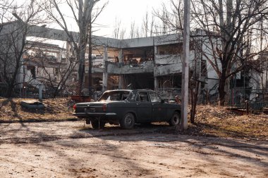 Ukrayna 'daki savaş, Rus birliklerinin bombardımanından sonra bir anaokulu binasının yıkıntılarına karşı bozulmuş bir araba.