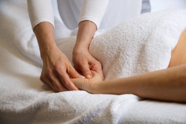 Kaplıca salonunda yağı olan bir kıza el masajı yapan bir masözün elleri, rahatlama konsepti, vücut bakımı konsepti.