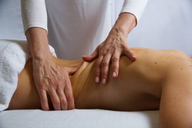 Spa salonunda bir kıza sırt masajı yapan bir masözün elleri, yan görüş, rahatlama konsepti, fotokopi alanı konsepti