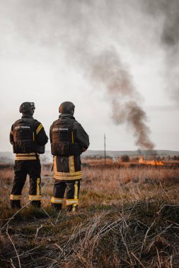 İki Ukraynalı itfaiyeci yangının nasıl söndürüleceğini analiz ediyor. Bahar orman yangınları şiddetleniyor. Kuru otları yakıyor, tarlada sazlıklar. Otlar çayırda yanıyor. Ekolojik felaket.