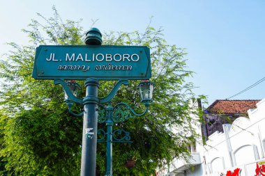 Yogyakarta 'daki Malioboro Caddesi işaret direği temiz bir gökyüzü geçmişine sahip. Malioboro, Java adasındaki en popüler geleneksel turlardan biridir..