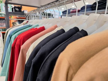 Askılarda renkli kıyafetler ve süpermarketlerde satılıyor..