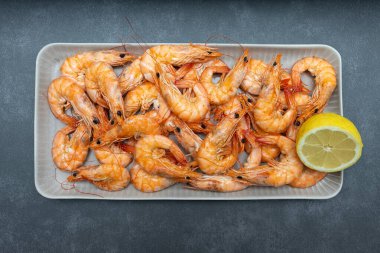 Pişmiş karides tabakta. Bir sürü limonlu kaplan karidesi.