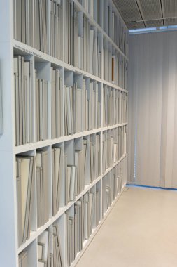 Ofiste dokümanlarla dolu bir raf duvarı. Kağıt belgelerinin geniş arşivi