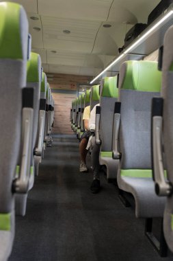 Modern bir yolcu treninin boş kabini. Trenin yolcu bölümünde boş yeşil koltuklar, koridorun manzarası. Bir adam tren yolculuğundan hoşlanır. Trenle yolculuk. Almanya 'da ulaşım.