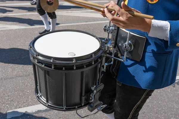 Musical instrument. The musician beats the drum. A drummer beats a drum marching down the street, close-up photo.