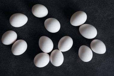 Taze tavuk yumurtasıyla dolu bir hayat. Siyah arka planda beyaz tavuk yumurtaları..