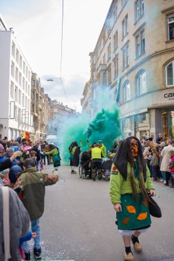 Stuttgart, Almanya 13 Şubat 2024. Almanya 'da karnaval alayı. Tatil boyunca yanan yeşil bir duman meşalesi.