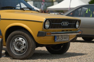 Kirchheim unter Teck, Almanya 11 Haziran 2025. Sarı Audi 80 B1 Klasik Araba Ön Görünümü. Sarı Audi 80 model klasik bir arabanın ön görüntüsü klasik tasarımını ve yuvarlak farlarını temiz bir şekilde gösteriyor..