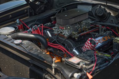 Stuttgart, Almanya 3 Ağustos 2025. Klasik arabada Edelbrock karbüratörü olan yüksek performanslı V8 motor. Güçlü V8 motor Edelbrock karbüratörü, canlı kablolama ve retro arabanın motor bölümünde özel bileşenler..
