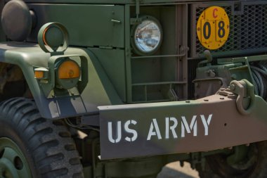 Amerikan askeri kamyonunun önünde. Üzerinde işaretler, ışıklar ve yeşil arkaplan olan Amerikan askeri kamyonunun bir parçası..