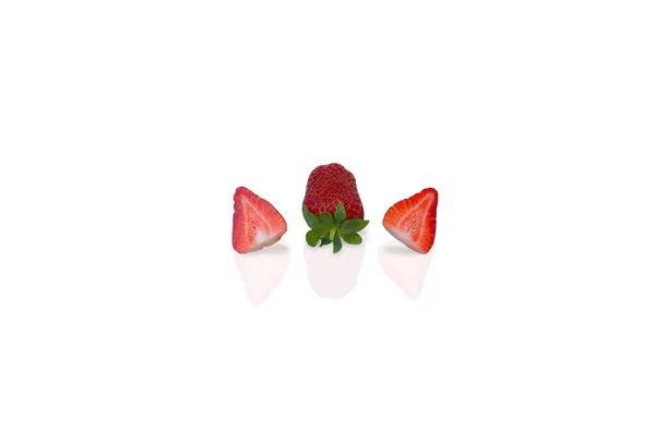 一个成熟美味 芬芳的草莓和两半草莓躺在白色的丙烯酸上 与白色的背景隔离 — 图库照片