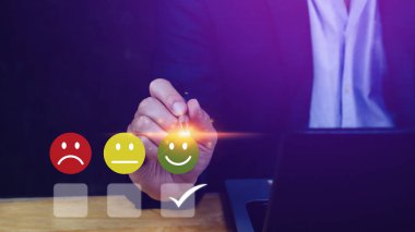 İş adamı gülen surat ikonunu seçiyor. Geri bildirim derecesi ve olumlu müşteri değerlendirme deneyimi, memnuniyet anketi. Akıl sağlığı değerlendirmesi. Dünya Ruh Sağlığı Günü konsepti