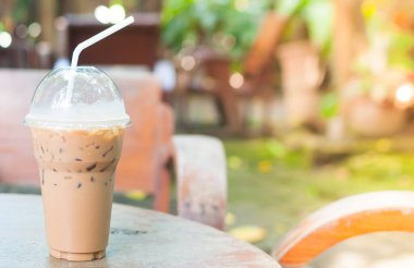 Bahçedeki masada, kahve köşesinde plastik bardakta buzlu kahve.