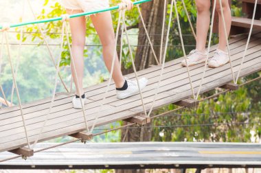 Turist ahşap asma köprüsünde uzaklaşıyor, ormanın diğer tarafına geçiyor.