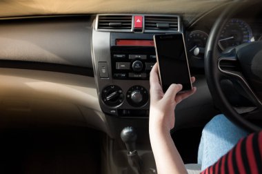 Bağımlı sosyal medya yüzünden araba kullanırken akıllı telefon kullanan bir kadın