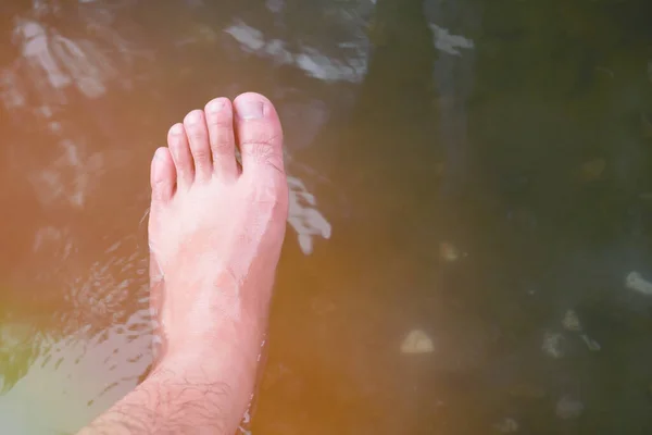 Soaking foot in the water at hot spring foot bath for therapy