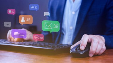 Sosyal medya ve dijital çevrimiçi pazarlama kavramlarını kullanan insanlar, akıllı telefon ekranında uyarılar, mesajlar, yorumlar gibi simgelerin bulunduğu dizüstü bilgisayarlarda.
