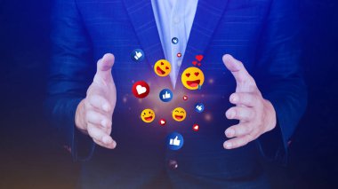 Sosyal medya ve çevrimiçi dijital konsept, iş adamı sosyal medya ile emoji gönderiyor. Çevrimiçi pazarlama kavramları kullanan ve dijital kullanan insanlar