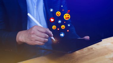 Sosyal medya ve çevrimiçi dijital konsept, İş adamı sosyal medya ile emoji gönderen dizüstü bilgisayar kullanıyor.
