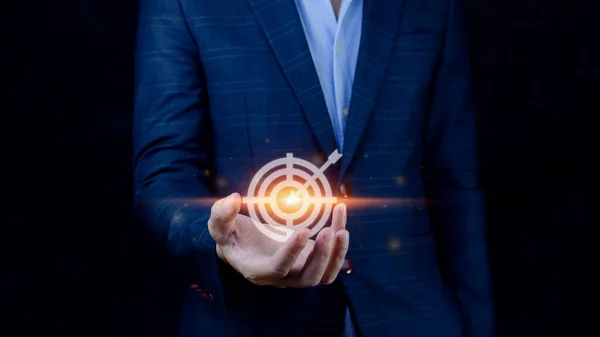 Targeting concept with businessman hand holding digital image of dartboard,Businessman holding virtual dartboard and arrow with copy space for setup business objective target concept.