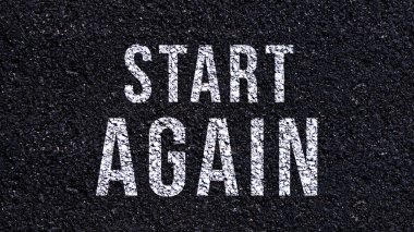 Asfalt yolda yazılan ve sarı çizgili metni yeniden başlat, caddede tekrar başlat.