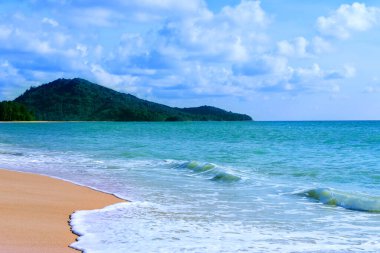 Açık mavi deniz dalgaları ve temiz kumsaldaki ada, tropik beyaz kum plajı ve yumuşak güneş ışığı arka planı