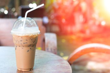 Bahçedeki masada, kahve köşesinde plastik bardakta buzlu kahve.