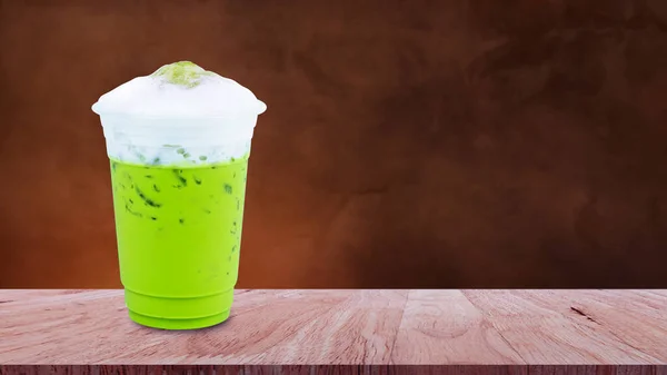 冰沙绿茶拿铁咖啡加牛奶泡沫在木桌上的外卖杯 夏天加冰的饮料 — 图库照片